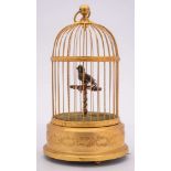 A 20th Century French musical bird in gilded cage: the feathered bird on a T-shaped perch,