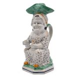 A late 18th century Prattware 'Martha Gunn' toby jug and cover: modelled seated and wearing a large