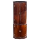 A mahogany bow-fronted standing corner cupboard:, in two sections,