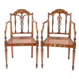 A set of four Sheraton period satinwood and decorated elbow chairs:, painted with floral foliage,