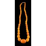 A graduated amber bead single-string necklace: with 52 oblong beads graduating on barrel clasp,