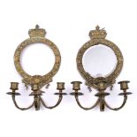 A pair of brass three-branch girandole mirrors: each circular backplate surmounted by a crown,