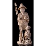 A large Japanese carved sectional ivory figure of a fisherman and son: the smiling man holding a