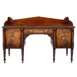 A Regency Scottish carved mahogany sideboard:, with an angled arch three quarter ledge back,