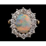 An opal and diamond oval cluster ring: with central oval opal approximately 11mm long x 9mm wide,