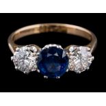A sapphire and diamond three-stone ring: the oval sapphire approximately 6.8mm long x 6.