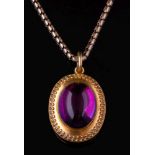 A Victorian gold and cabochon amethyst pendant locket on chain: with central oval cabochon amethyst