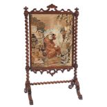 A Victorian mahogany barley twist fire screen with needlework panel.