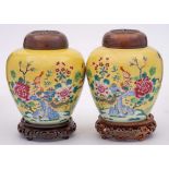 A pair of Chinese famille rose yellow ground ginger jars: each painted with a phoenix perched on