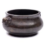 A Chinese bronze censer: of compressed circular form on an everted foot with finely cast opposing