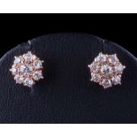 A pair of diamond mounted circular cluster ear-studs: with round brilliant-cut diamonds estimated