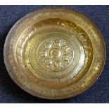 A Nuremberg brass alms dish: with central embossed decoration enclosed by two borders of script,