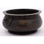 A Chinese bronze censer: of squat circular form, with stylized dragon mask handles to the sides,