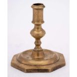 A 17th Century Spanish brass candlestick: with plain cylindrical nozzle on a knopped stem and domed