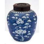 A Chinese porcelain jar: of oviform painted in blue with prunus below a narrow notched band,