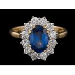 A sapphire and diamond oval cluster ring: with central oval sapphire approximately 8.5mm x 6.