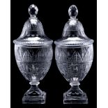 A pair of Georgian-style cut glass urns and covers: the domed covers with faceted finials,