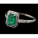 An Art Deco emerald and diamond rectangular cluster ring: with central emerald-cut emerald