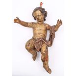 A Continental carved wood and polychrome decorated putto: draped with a robe over outstretched arms,