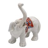 A Chantilly-style porcelain elephant: modelled with trunk raised and wearing a saddle cloth