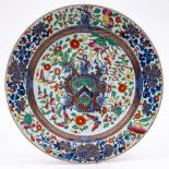 A large Chinese porcelain armorial charger: painted in underglaze blue with the arms and crest of