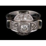 An Art Deco diamond mounted cluster ring: mille-grain-set with a central round brilliant-cut