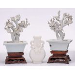 A pair of Chinese blanc de chine blossom tree ornaments and a similar small vase: two birds perched