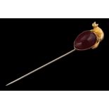 A 19th Century cabochon garnet and fox motif mounted stick pin: the pear-shaped cabochon garnet