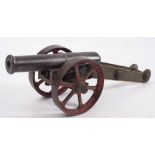 A Victorian iron and steel cannon: the 8 1/2 inch two stage barrel on a green painted steel frame