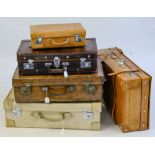 A group of seven various suitcases,: including a vellum suitcase,