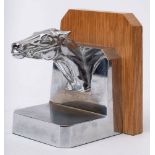 A nickel plated car mascot bookend in the form of the head of a race horse,: on wooden plaque.