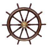 A 19th Century teak and brass ships helm:, the central iron boss with domed brass cap,