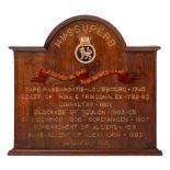 A carved oak honours board for HMS Superb: the arched top above ship's name and badges with action