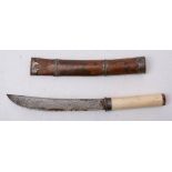 A Burmese dha dagger: the short curved back blade over a white metal hilt and one piece ivory grip,
