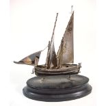 A Continental silver model of a fishing boat: set full sails, mounted on an oval ebony socle,