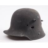 A WWI German M16 pattern helmet with bullet strike to one side and exit damage to rear: (over