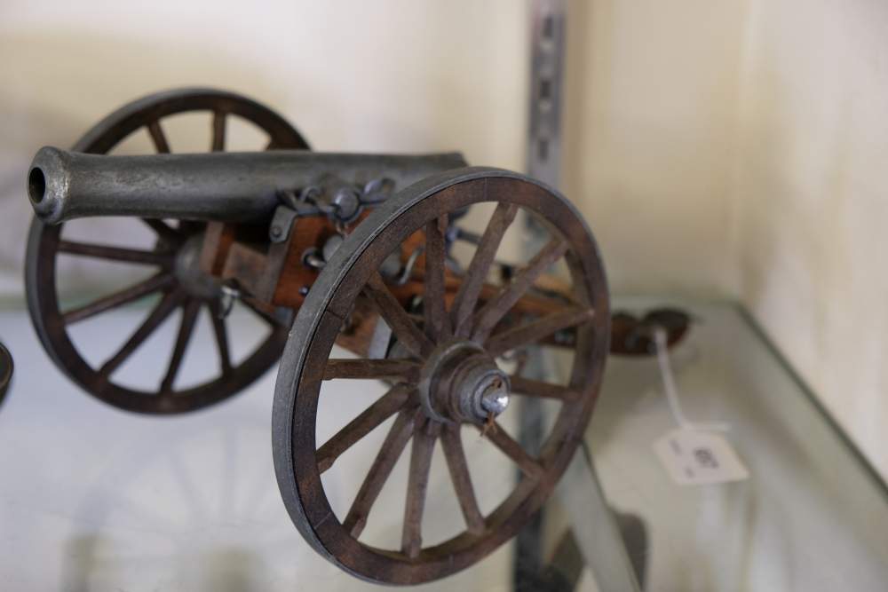 A scale model of a field gun: with diecast barrel and fittings on a wooden truck.