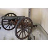 A scale model of a field gun: with diecast barrel and fittings on a wooden truck.