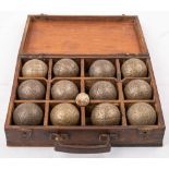 A cased set of bronze petanque: