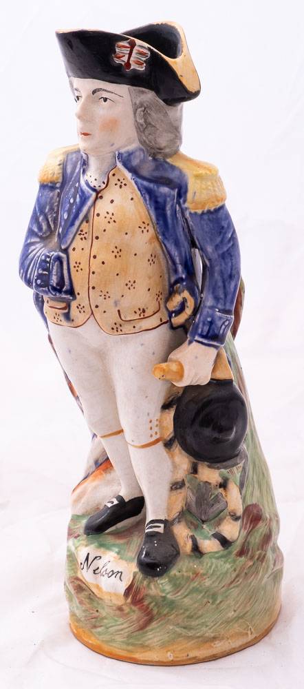 A Staffordshire character jug modelled as Admiral Lord Nelson: standing beside a cannon and holding - Image 3 of 3