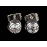 A pair of platinum and diamond single-stone ear-studs: each with a round old,