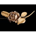 An 18ct gold 'rose' brooch: the reverse stamped 'TAD', with attached safety chain,