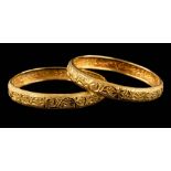 A pair of foliate engraved bangles: each approximately 60mm internal diameter,