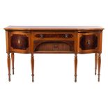 An Edwardian mahogany, banded and inlaid sideboard: of shaped front outline,