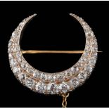 A Victorian diamond mounted two-row crescent brooch: set with graduated round old,