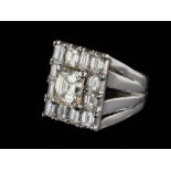 A diamond mounted rectangular cluster ring: with central emerald-cut diamond approximately 7.