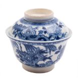 A Chinese blue and white soft paste rice bowl and cover: painted with prunus,