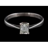 A diamond solitaire ring: the emerald-cut diamond approximately 5.0mm long x 3.9mm wide x 2.