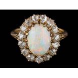 An opal and diamond oval cluster ring: the oval opal approximately 10.5mm long x 7.5mm wide x 3.