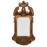 A Continental walnut and giltwood wall mirror: of cartouche outline,